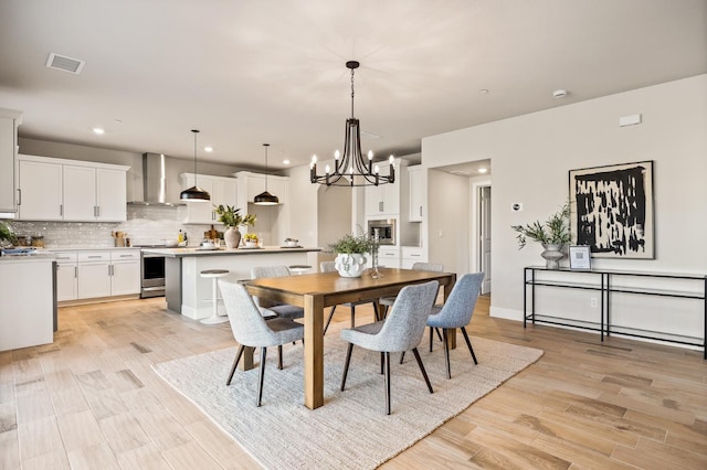 dining room with an inviting chandelier and light hardwood / wood-style floors