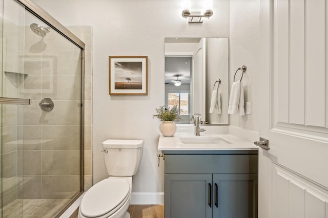 bathroom featuring toilet, vanity, wood-type flooring, and a shower with door