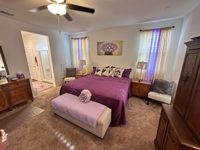 carpeted bedroom with ceiling fan and ensuite bath