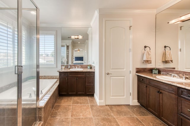 full bathroom featuring ornamental molding, a stall shower, two vanities, and a sink