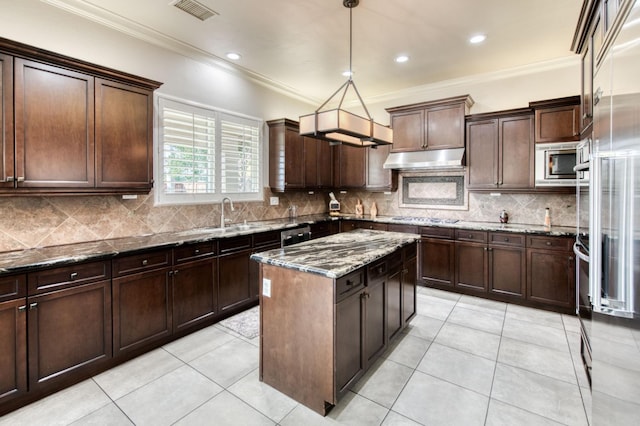 kitchen featuring under cabinet range hood, a sink, visible vents, appliances with stainless steel finishes, and dark stone counters