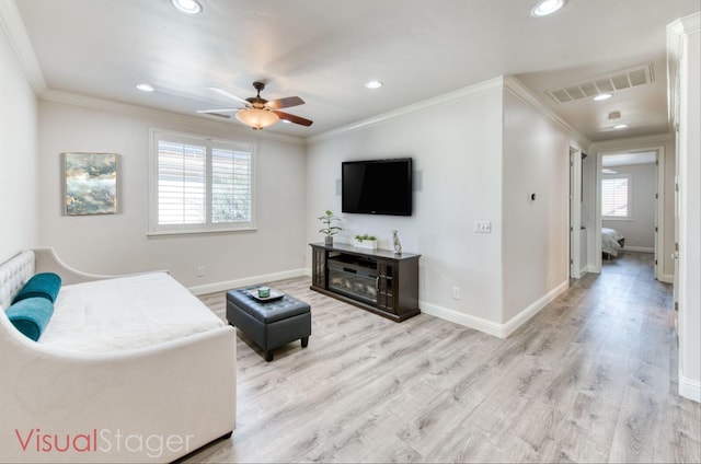 living area with baseboards, visible vents, crown molding, and wood finished floors