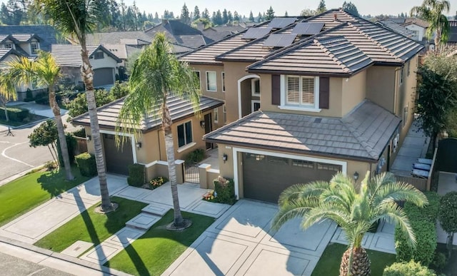 view of front of property with fence, a tile roof, concrete driveway, a gate, and stucco siding