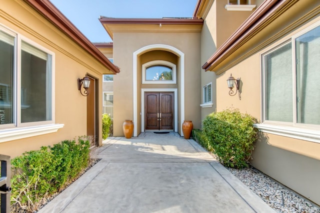 doorway to property featuring stucco siding