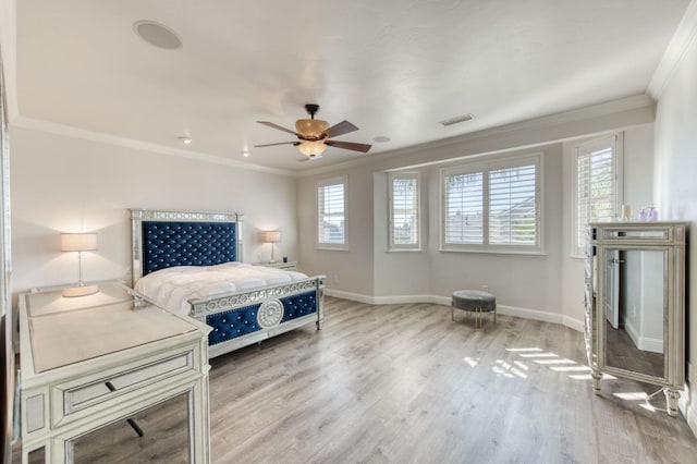 bedroom featuring a ceiling fan, visible vents, baseboards, ornamental molding, and light wood finished floors