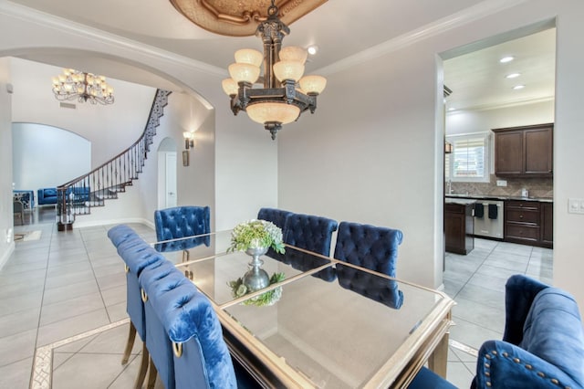 dining space with light tile patterned floors, arched walkways, stairway, crown molding, and a chandelier