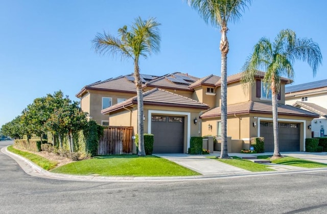 view of front of property with stucco siding, concrete driveway, fence, a garage, and a tiled roof