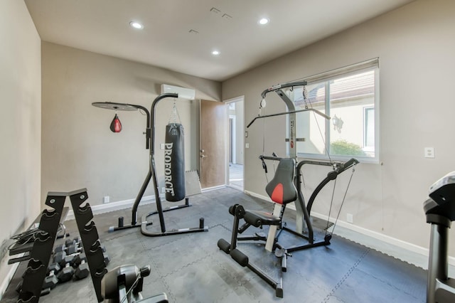 exercise area with a wall unit AC, baseboards, and recessed lighting