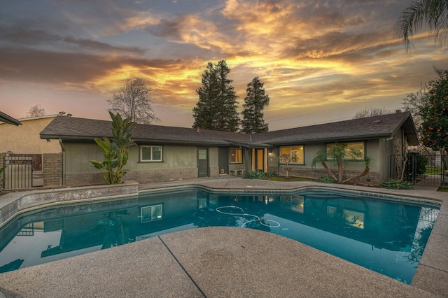 pool at dusk with a patio