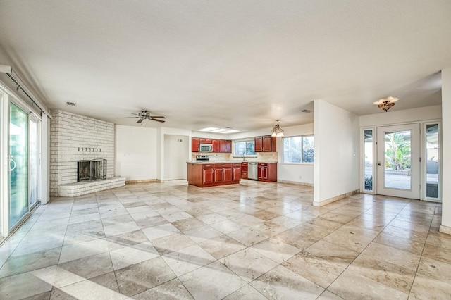 unfurnished living room with a fireplace and ceiling fan