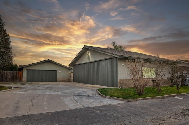 property exterior at dusk featuring an outbuilding and a garage