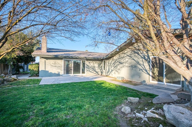 back of property featuring a patio area and a lawn