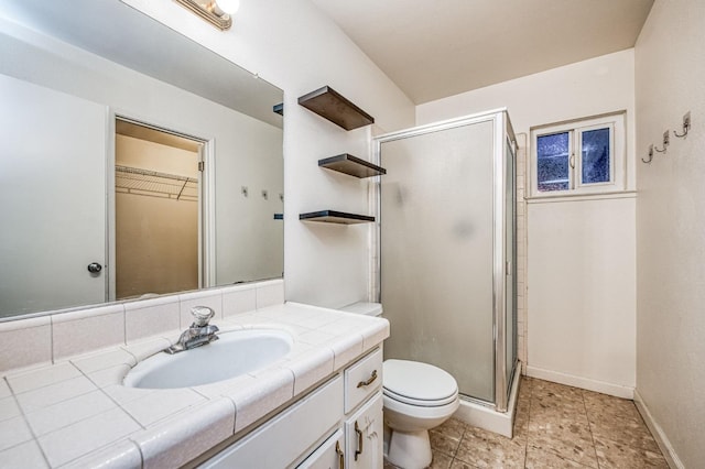 bathroom with vanity, a shower with shower door, and toilet