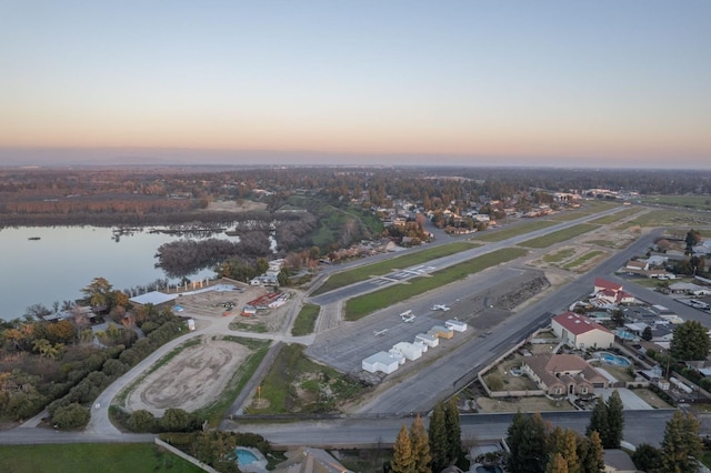 aerial view at dusk featuring a water view