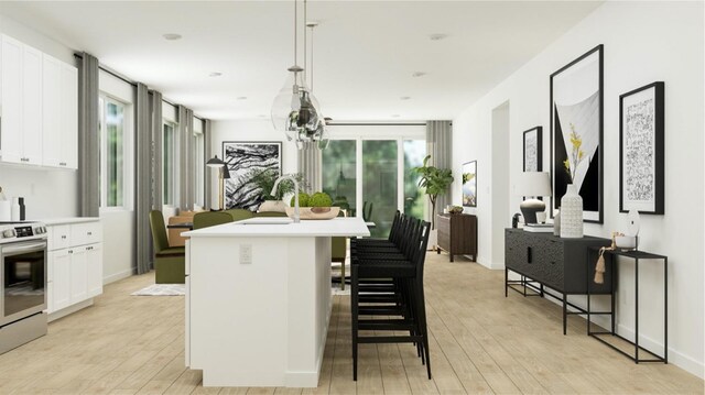 kitchen with stainless steel electric range oven, white cabinetry, a kitchen island with sink, pendant lighting, and a breakfast bar area