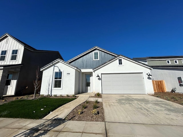 view of front of property featuring stucco siding, an attached garage, and driveway