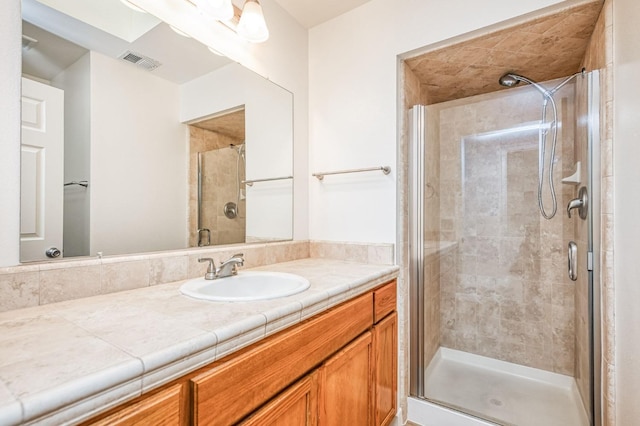 bathroom with vanity and a shower with shower door