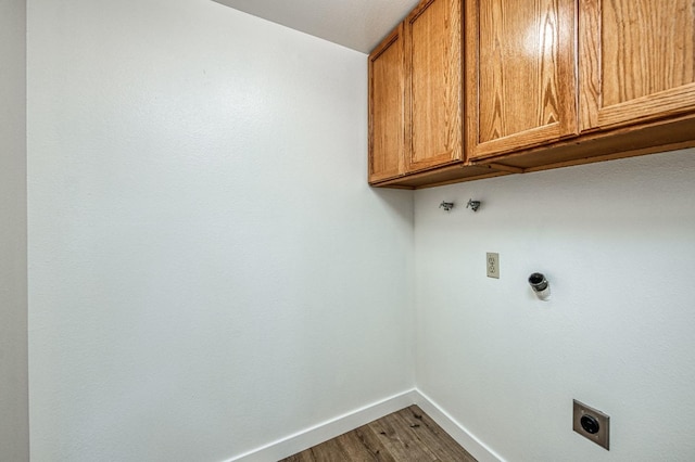 washroom with wood-type flooring, electric dryer hookup, and cabinets