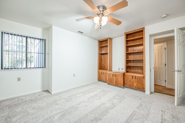 unfurnished bedroom featuring light carpet and ceiling fan