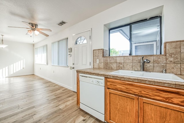 kitchen featuring sink, a healthy amount of sunlight, light hardwood / wood-style flooring, and white dishwasher