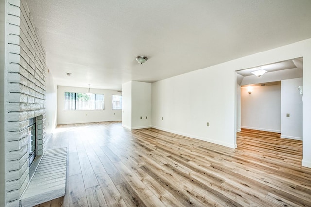 unfurnished living room featuring a fireplace and light hardwood / wood-style flooring