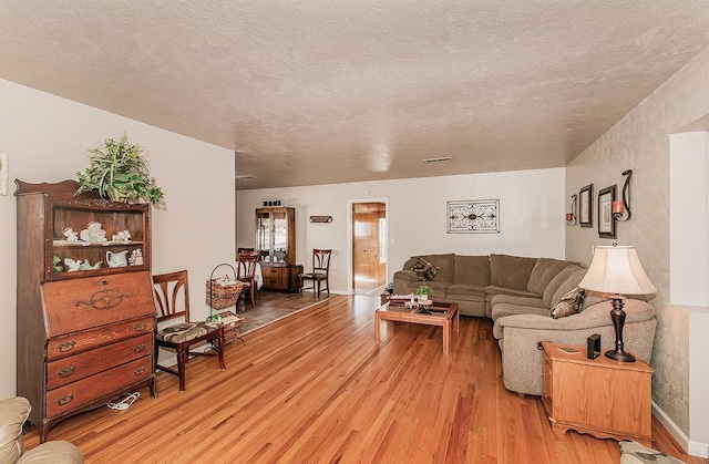 living room featuring hardwood / wood-style flooring and a textured ceiling