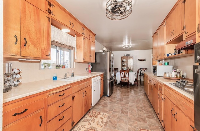 kitchen with sink, appliances with stainless steel finishes, and tile countertops