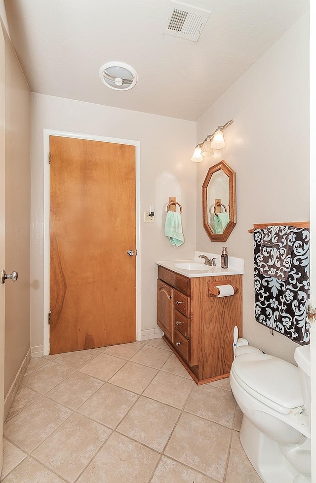 bathroom with toilet, tile patterned flooring, and vanity