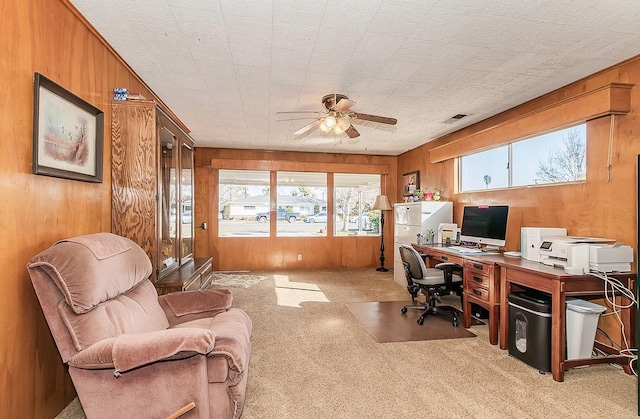 office featuring wood walls, light colored carpet, and ceiling fan