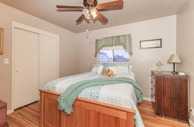 bedroom featuring light hardwood / wood-style floors, a closet, and ceiling fan