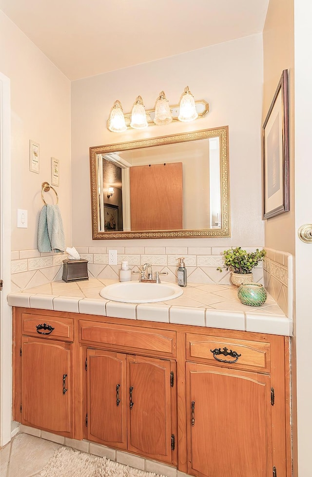 bathroom featuring tasteful backsplash, tile patterned floors, and vanity