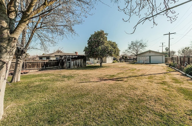 view of yard with a garage and an outbuilding