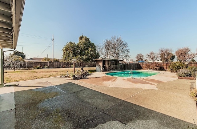 view of swimming pool with a storage unit, a patio area, and a yard