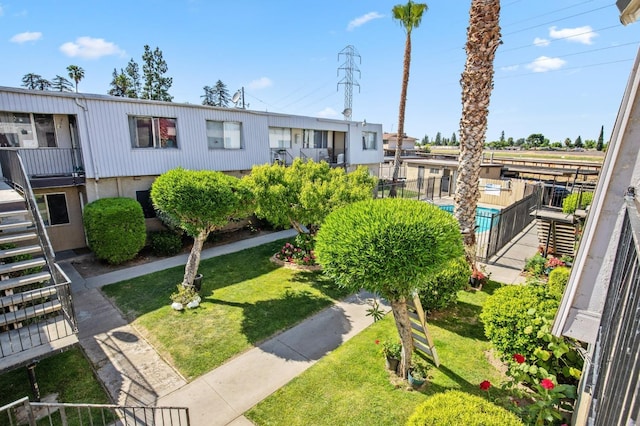 view of property's community featuring a swimming pool and a lawn