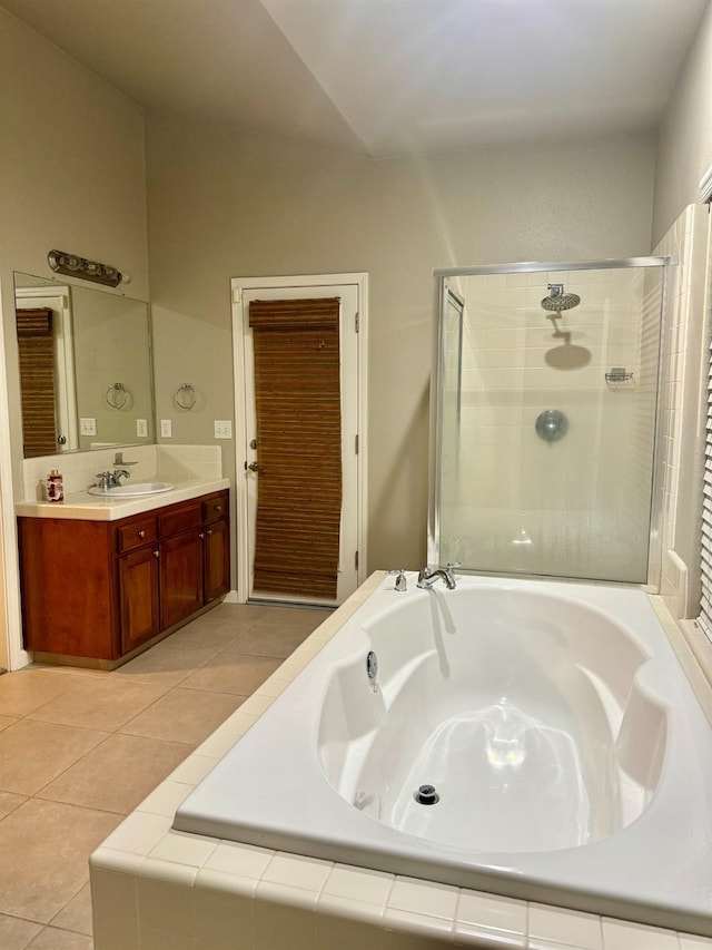 bathroom featuring plus walk in shower, vanity, and tile patterned flooring