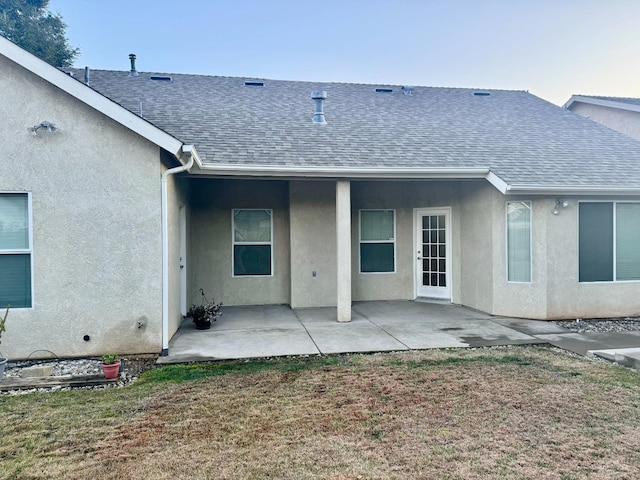 rear view of house with a lawn and a patio