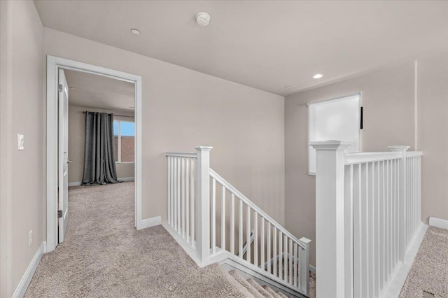 hallway featuring light colored carpet