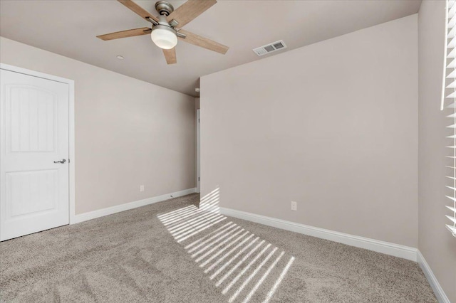 unfurnished room with ceiling fan and carpet