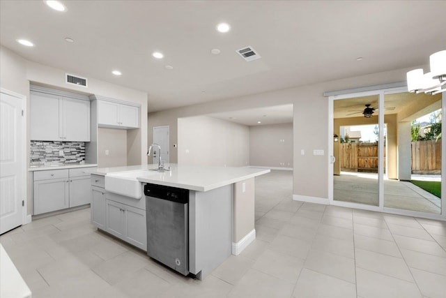 kitchen with sink, decorative backsplash, a kitchen island with sink, stainless steel dishwasher, and ceiling fan