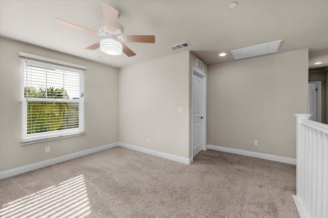 empty room featuring ceiling fan and light colored carpet