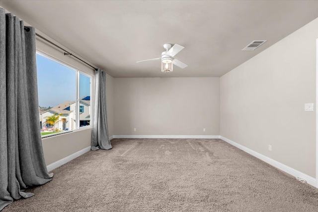 carpeted spare room with ceiling fan