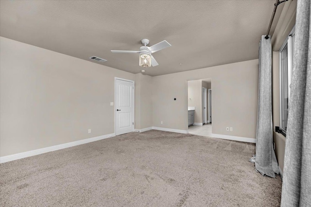 unfurnished room with ceiling fan, light carpet, and a textured ceiling