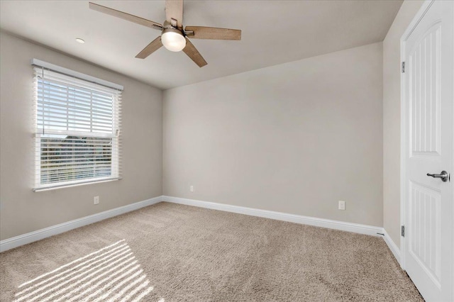 empty room with ceiling fan and light carpet