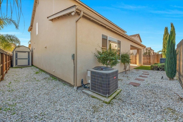 view of property exterior featuring central AC, a storage shed, and a patio