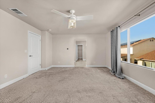 spare room with ceiling fan and light colored carpet