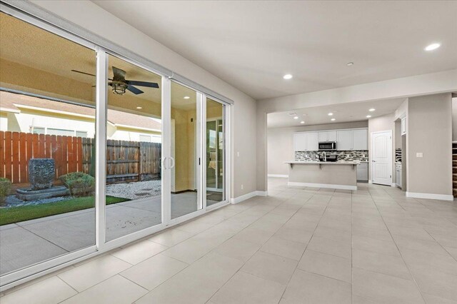 unfurnished living room with ceiling fan