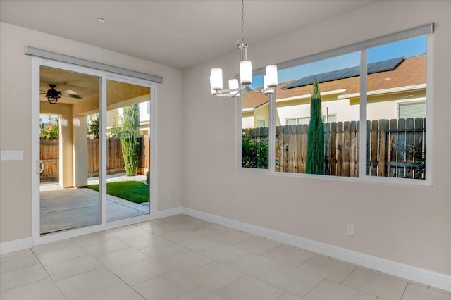 unfurnished room featuring ceiling fan with notable chandelier