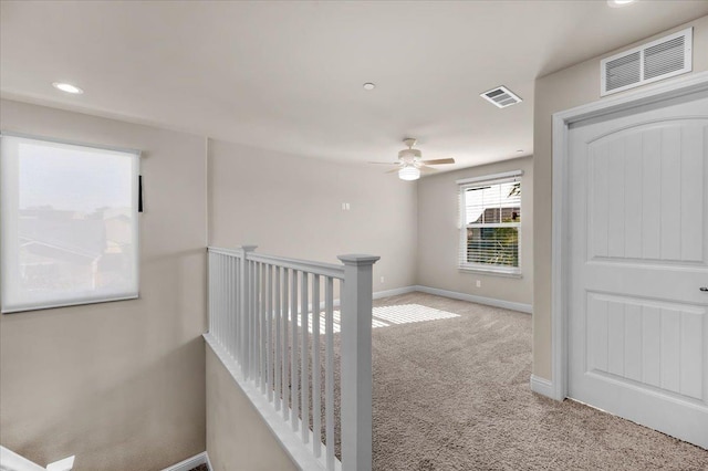 corridor featuring light colored carpet