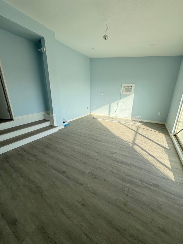 spare room with visible vents, baseboards, and wood finished floors