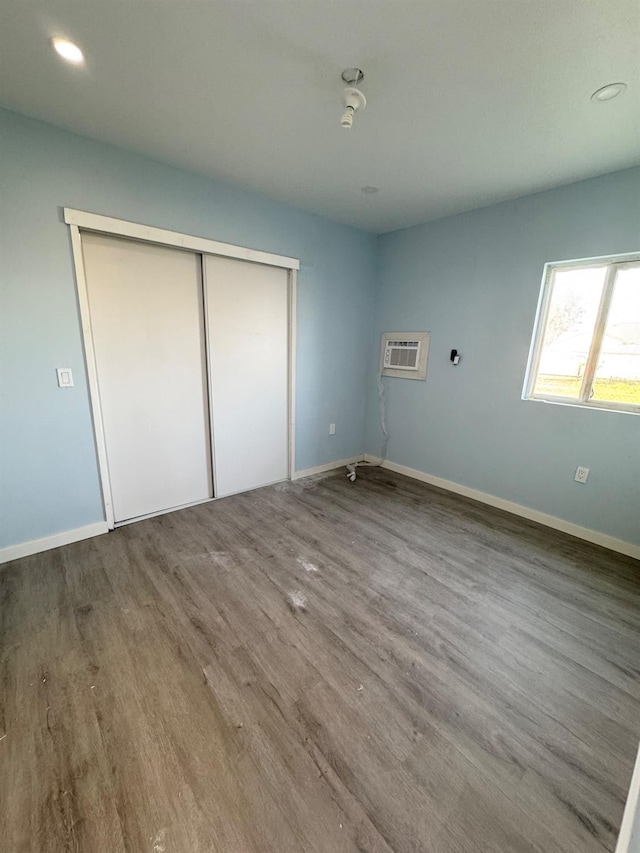 unfurnished bedroom featuring recessed lighting, wood finished floors, baseboards, and a closet